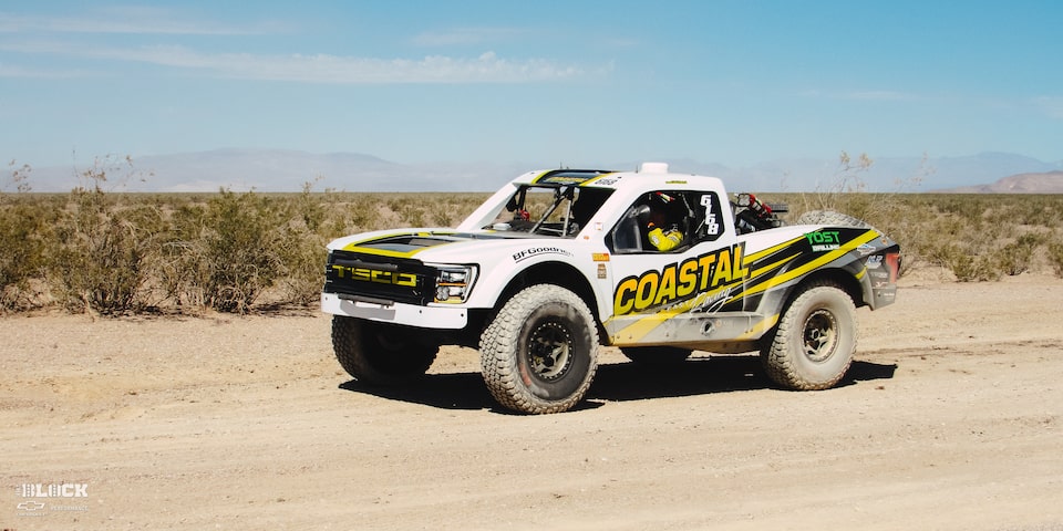 Front Side View of an Off-Road Chevy Truck Driving Through the Desert