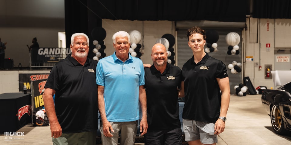 Jim Meyer (blue shirt) flanked by members of the Ron Jones Garage team, including Ron to his left.