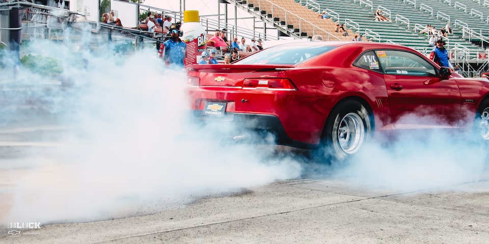 Rear Side View of a Chevy Copo Camaro Doing a Burnout on a Racetrack
