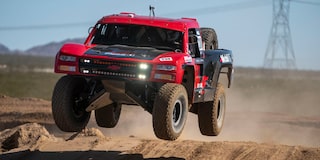 A Large Red Chevy Truck with Huge Tires Flies Above the Dirt Track at the BFGoodrich Tires Mint 400