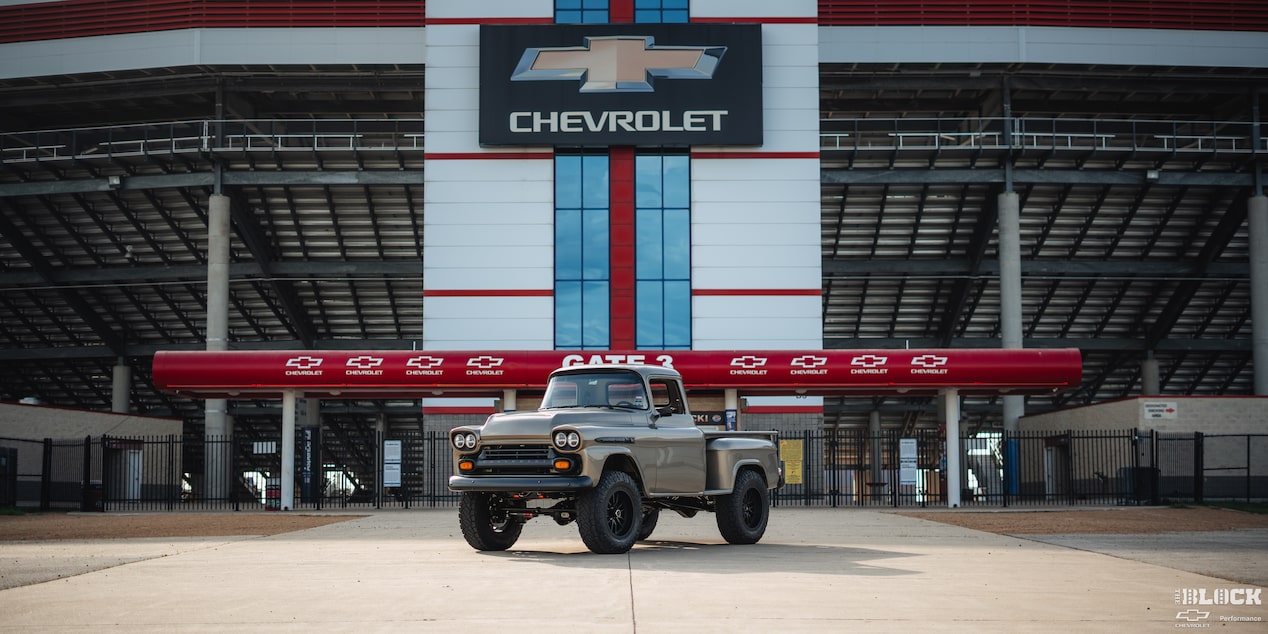 Faraway View of a 1958 Chevy Apache in Front of a Stadium Gate with the Chevrolet Logo on Top