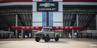 Faraway View of a 1958 Chevy Apache in Front of a Stadium Gate with the Chevrolet Logo on Top