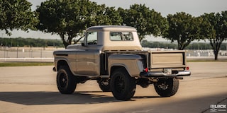 Three Quarters Rear View of a Silver 1958 Chevy Apache Pickup Truck on a Sunny Day with Trees Seen in the Distance