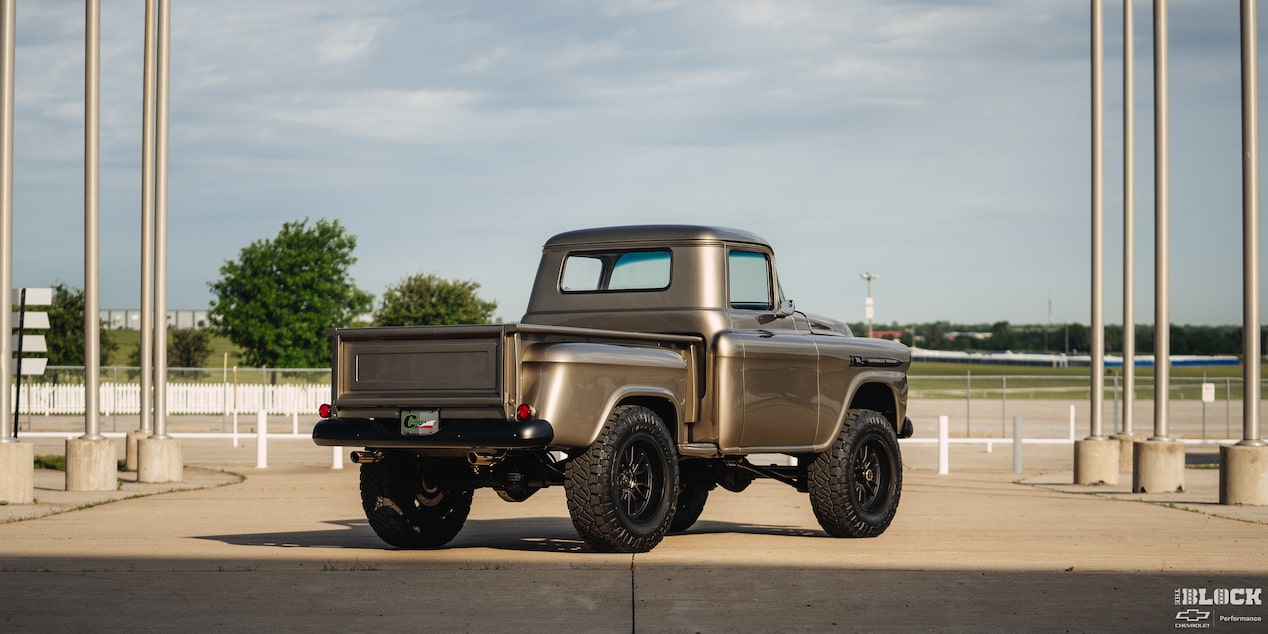 A Three Quarters Rear View of a 1958 Silver Chevy Apache Pickup Truck Under a Clear Blue Sky