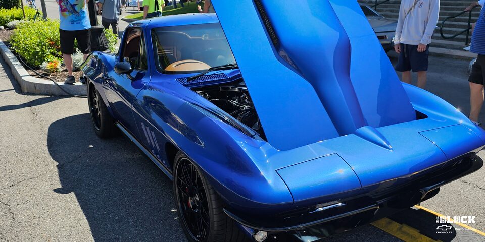 Three Quarters View of a Blue Chevy C2 Corvette with Its Hood Open on a Sunny Day