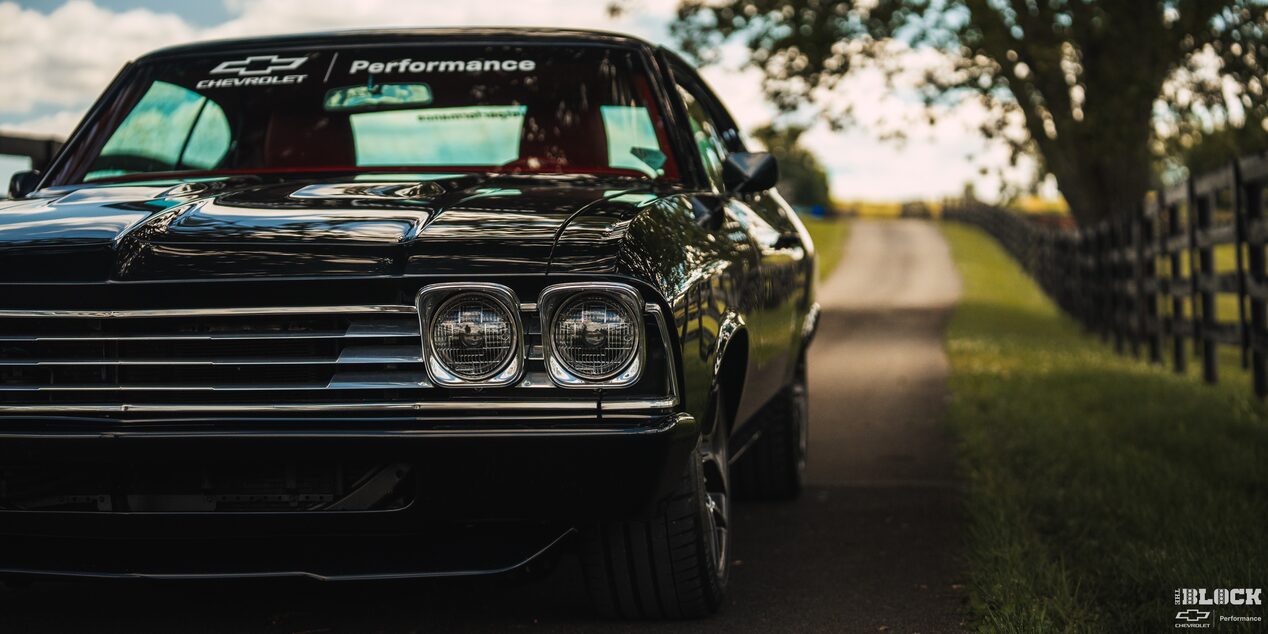 Eye Level View of the Left Side of the 1969 Chevy Chevelle on the Left Frame Surrounded by Trees and Grass