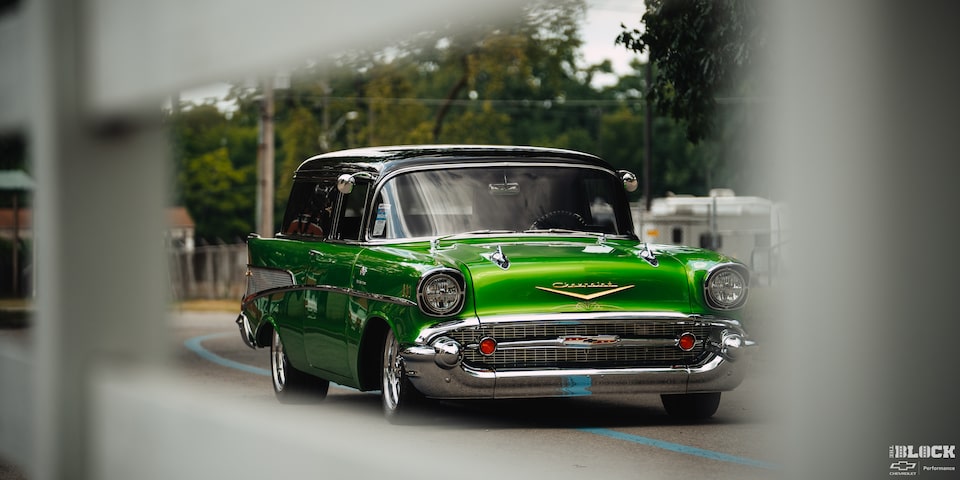 A View of a Synergy Green 1957 Chevrolet Sedan Delivery Through a Building Window