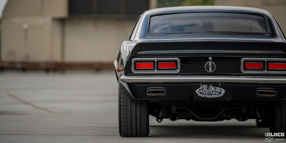 Rear View of a 1968 Black Chevy Camaro Placed at the Edge of the Frame