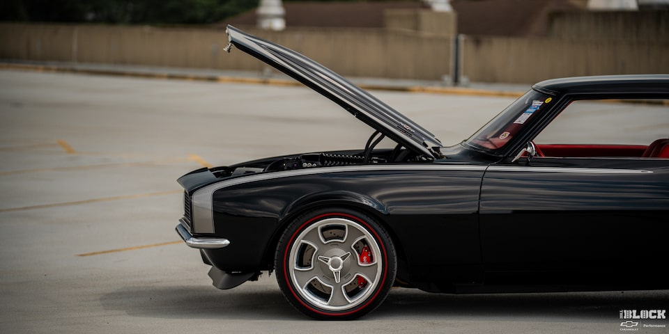 Side View of a Black 1968 Chevrolet Camaro with Its Hood Open in an Empty Lot