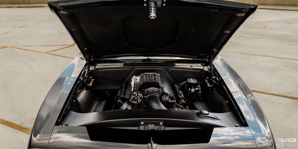 Close-up Front View of a Black 1968 Chevy Camaro with its Hood Open and Engine Exposed