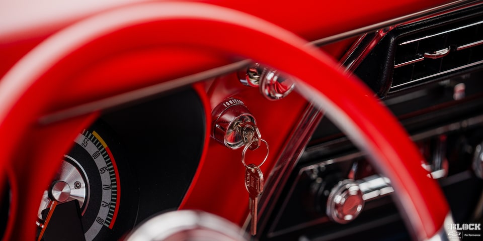 Close-up of an Engine Key in the Ignition Seen through the Red Steering Wheel of a 1968 Chevy Camaro