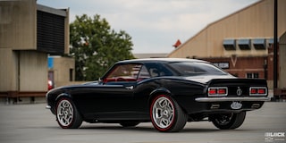 Three Quarters View of the Rear of a 1968 Black Chevy Camaro Surrounded by Buildings