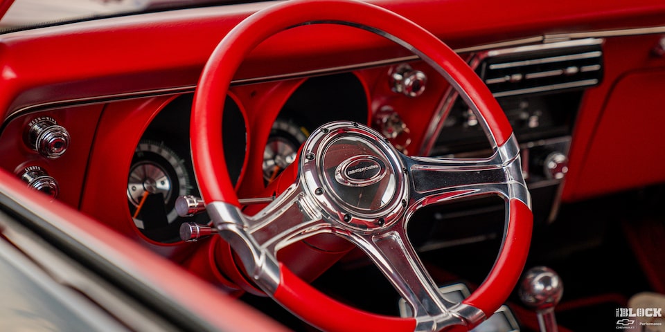 Close-up of Red Steering Wheel and Interior Viewed from the Outside the Left Window of a Chevy 1968 Camaro