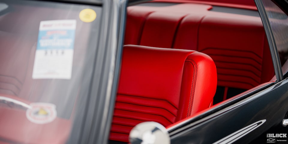 A Red Driver’s Seat Seen through the Window from Outside a 1968 Chevy Camaro