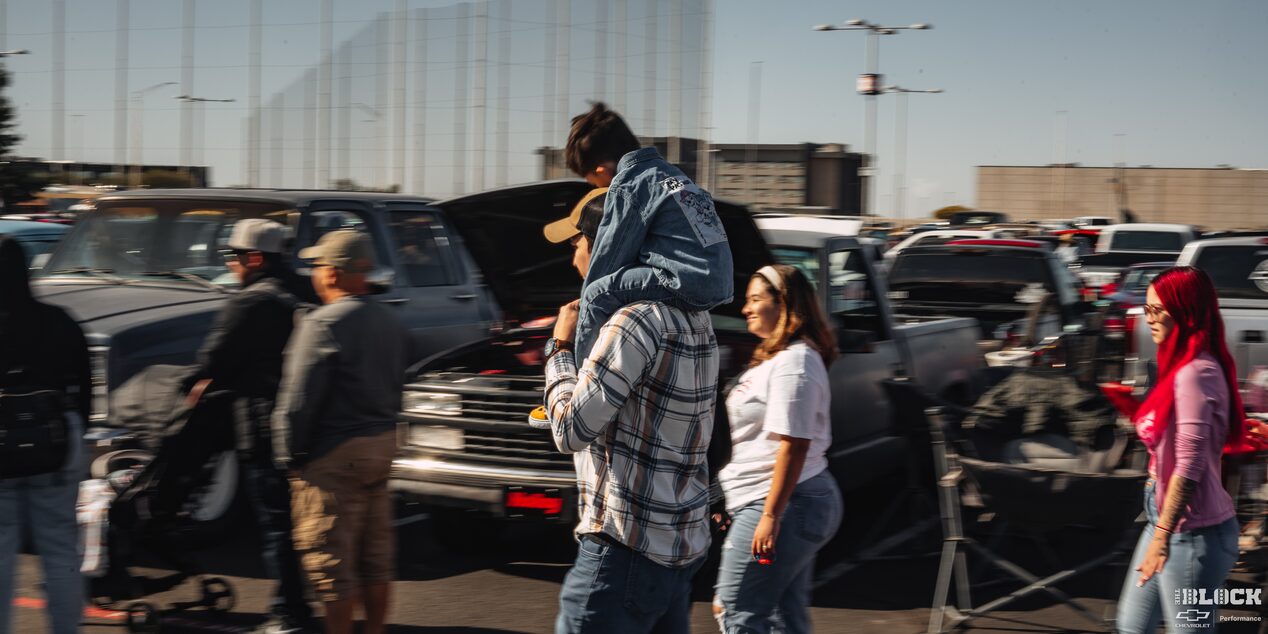 A Man Carrying His Son on His Shoulders with a Woman Next to Him Walking at Dino’s Git Down Event