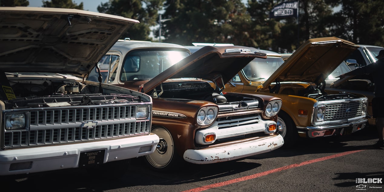 Three Quarters View of a Line of Chevy Vehicles with Their Hoods Open