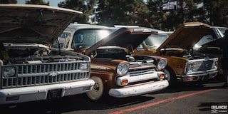 Three Quarters View of a Line of Chevy Vehicles with Their Hoods Open