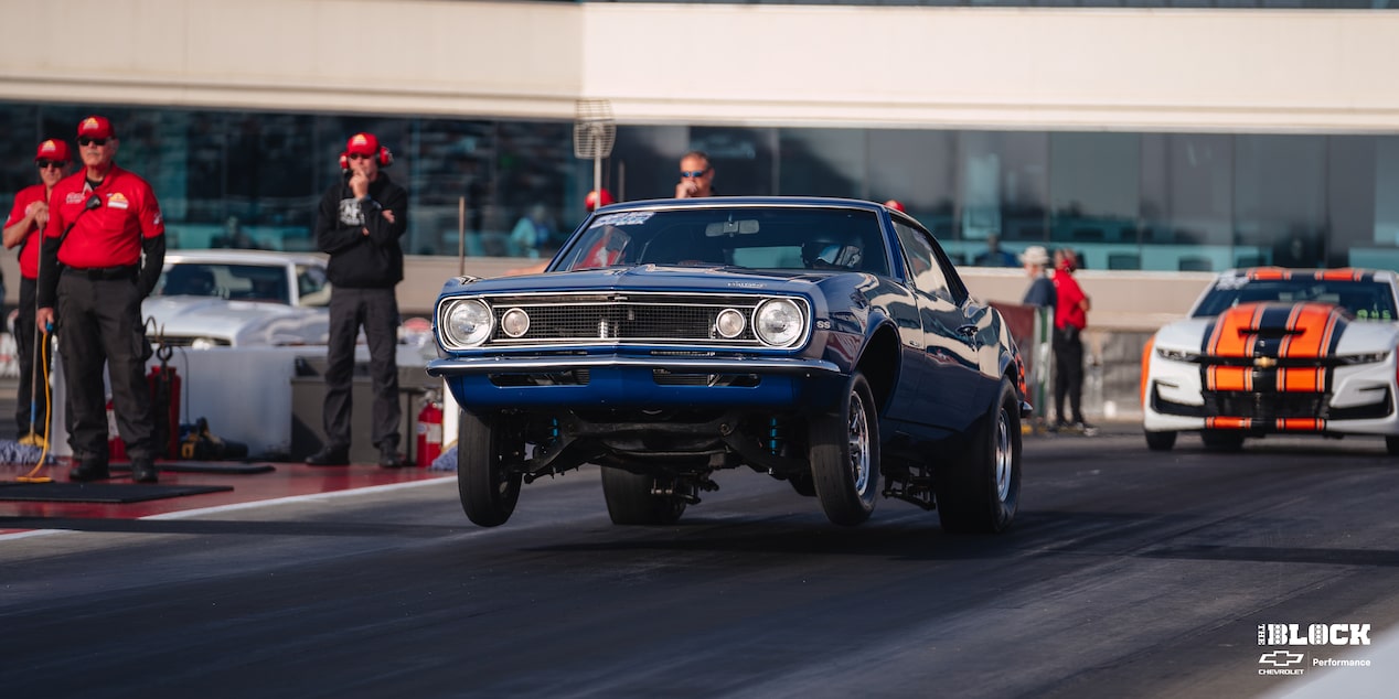 Three Quarters View of a Blue Chevy Racecar Accelerating with Its Front Portion Lifted Upwards from the Force