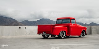 Wide Rear Three-Quarters View of David Kinnison's 1957 Chevrolet 3100 Truck in a Parking Lot