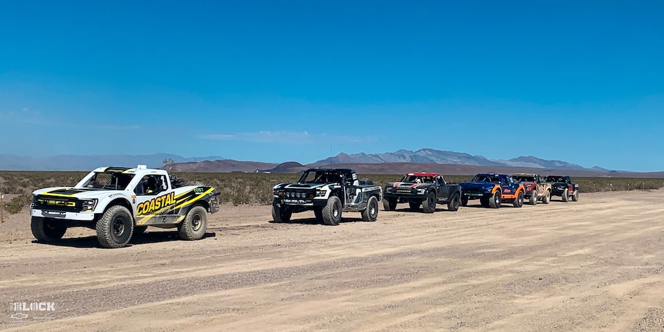Line-up of Racing Trucks on a Dirt Path