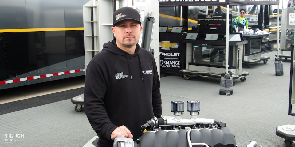 A Chevrolet Performance Representative Standing with a 525 RLB Chevrolet Performance Engine