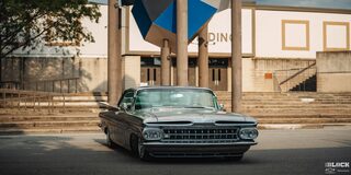 Front View of a 1959 Grey Chevy Impala in Front of a Building