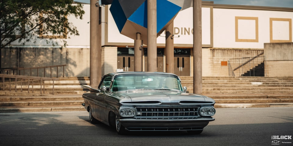 Front View of a 1959 Grey Chevy Impala in Front of a Building