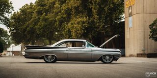 Side View of a 1959 Silver Chevy Impala with Its Hood Open on the Street