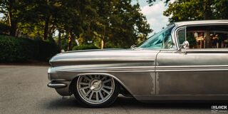 Front Side View of a 1959 Silver Chevy Impala on the Road