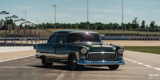Front Three Quarters View of a Dark Green 1955 Chevrolet on a Race Track
