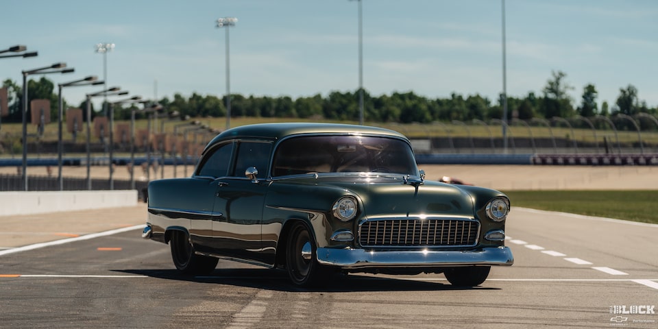 Front Three Quarters View of a Dark Green 1955 Chevrolet on a Race Track