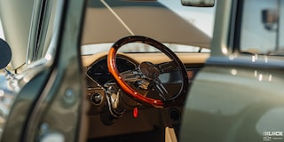 A Focused Shot of the Brown Steering Wheel from outside the Window of 1955 Chevrolet