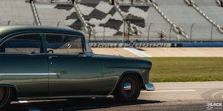 Three Quarters Rear View of a 1955 Chevrolet on a Racing Track under Sunny Day