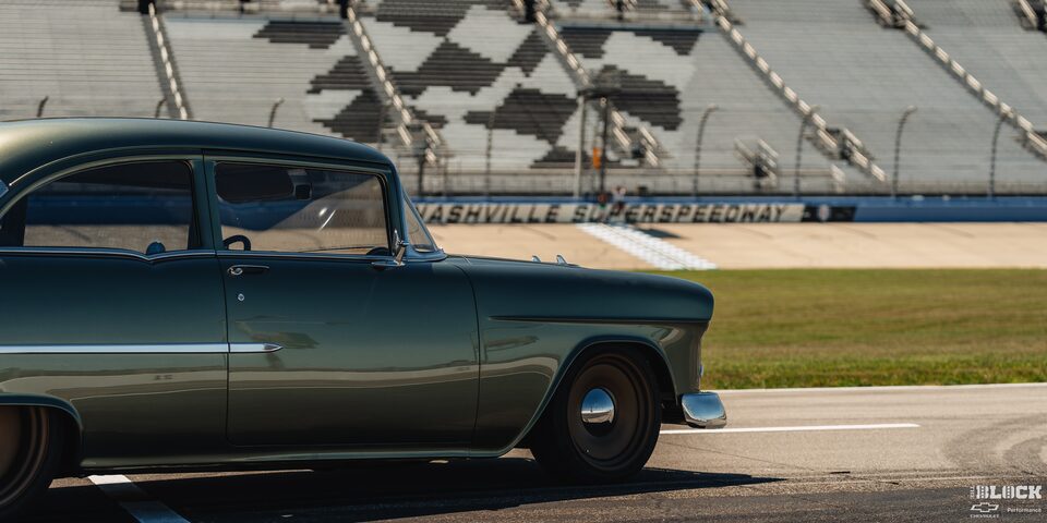 Three Quarters Rear View of a 1955 Chevrolet on a Racing Track under Sunny Day