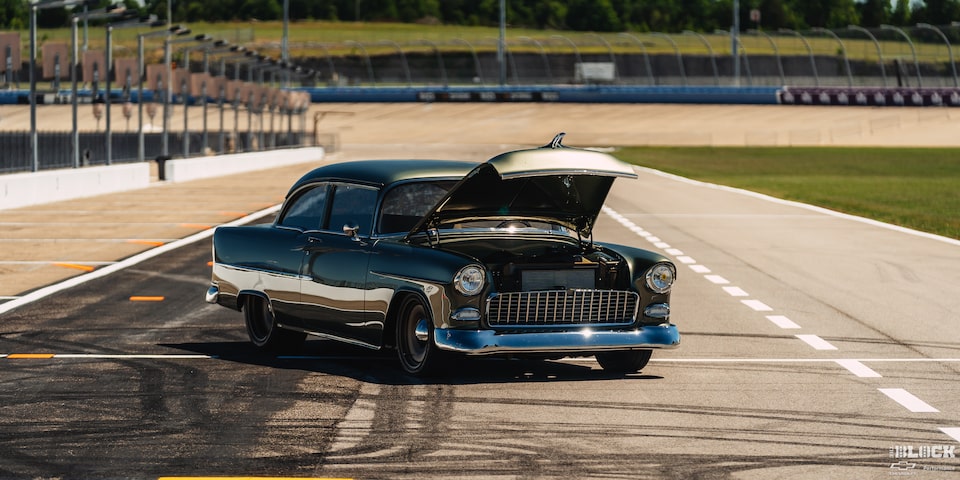 Three Quarters View of a 1955 Chevrolet with Its Hood Open on a Racetrack
