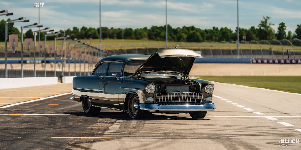 Three Quarters View of a 1955 Chevrolet with It’s Hood Open on a Racetrack