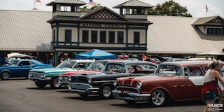 Cinco autos Chevy clásicos estacionados en una línea de exhibición en los Summit Racing Nationals