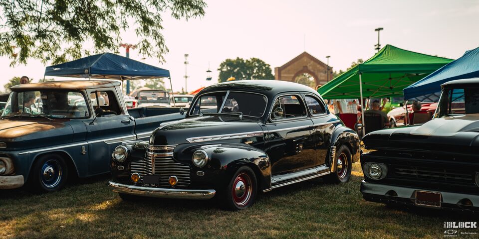 Tres vehículos clásicos de Chevrolet estacionados a la sombra en los Summit Racing Nationals de Columbus, OH