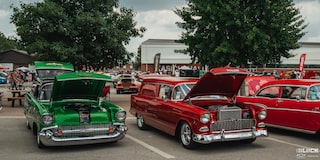 Una gama de autos Chevy clásicos estacionados con los cofres abiertos en los Goodguys Summit Racing Nationals