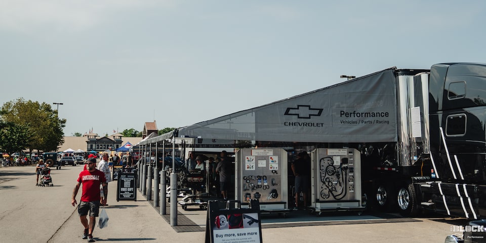 Una gama de autos Chevy clásicos estacionados con los cofres abiertos en los Goodguys Summit Racing Nationals