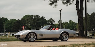 Side View of a 1969 Silver Chevy Corvette Parked with Trees in the Background