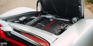 Angular View of a 1969 Silver Chevy Corvette Exposed Engine with the Hood Open and the Engine Labled "Corvette L53"