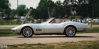 Side View of a 1969 Silver Chevy Corvette Parked with Its Engine Hood Open