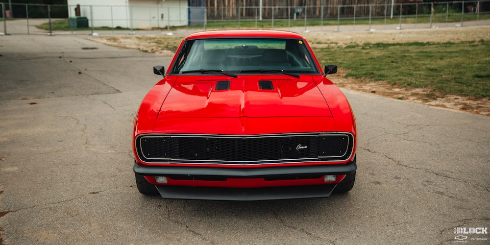 Front over the Eye View of a 1968 Chevy Camaro on a Ground Surrounded by Grassy Plain