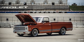 Vista de tres cuartos de una pickup Chevy C10 Naranja con el cofre abierto
