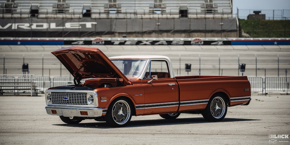 Vista de tres cuartos de una pickup Chevy C10 Naranja con el cofre abierto