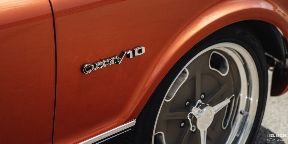Primer plano del emblema Chevy Custom/10 en la parte inferior izquierda del vehículo