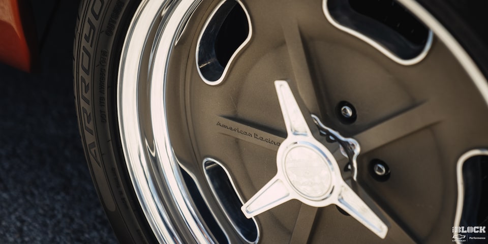 Primer plano de un neumático de una Chevy C10 con "American Racing" escrito en él