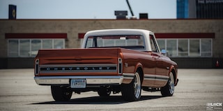 Vista trasera de una pickup Chevy C10 en un estacionamiento vacío