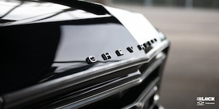 Vista en primer plano del cofre de una Chevrolet C10 1967 en Negro, con el adorno del cofre que dice "Chevrolet"